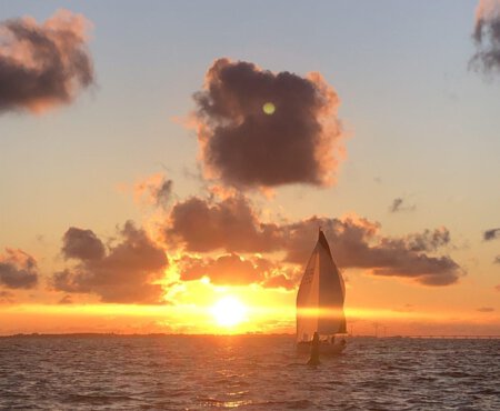 Zonondergang met zeilboot op zee