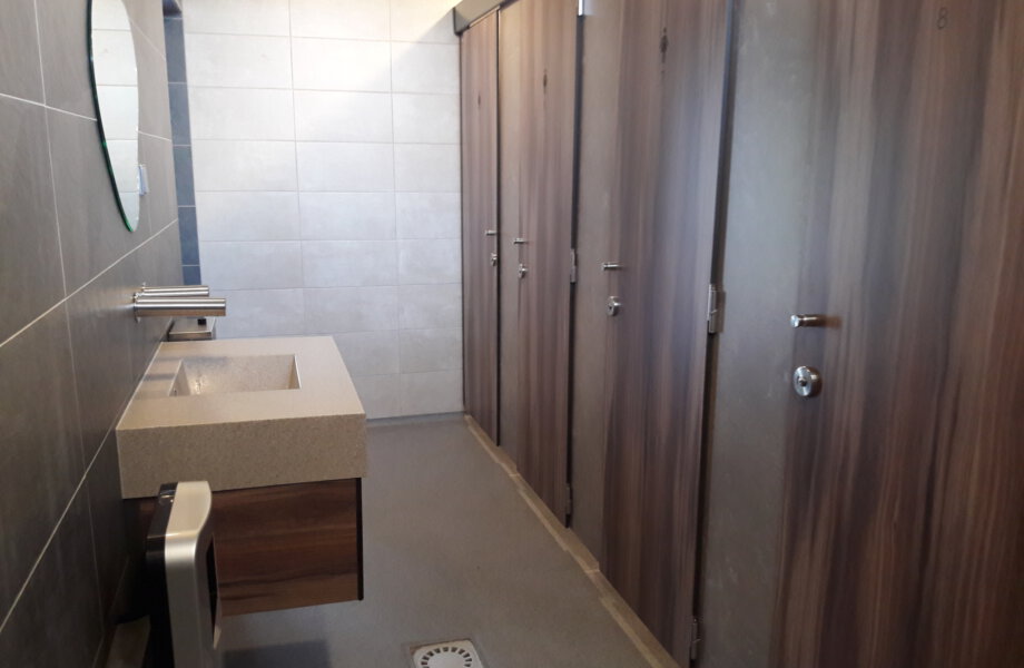 toiletgebouw met deuren en een wastafel