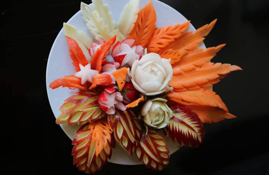 Groente en fruit sierlijk uitgesneden op een bord