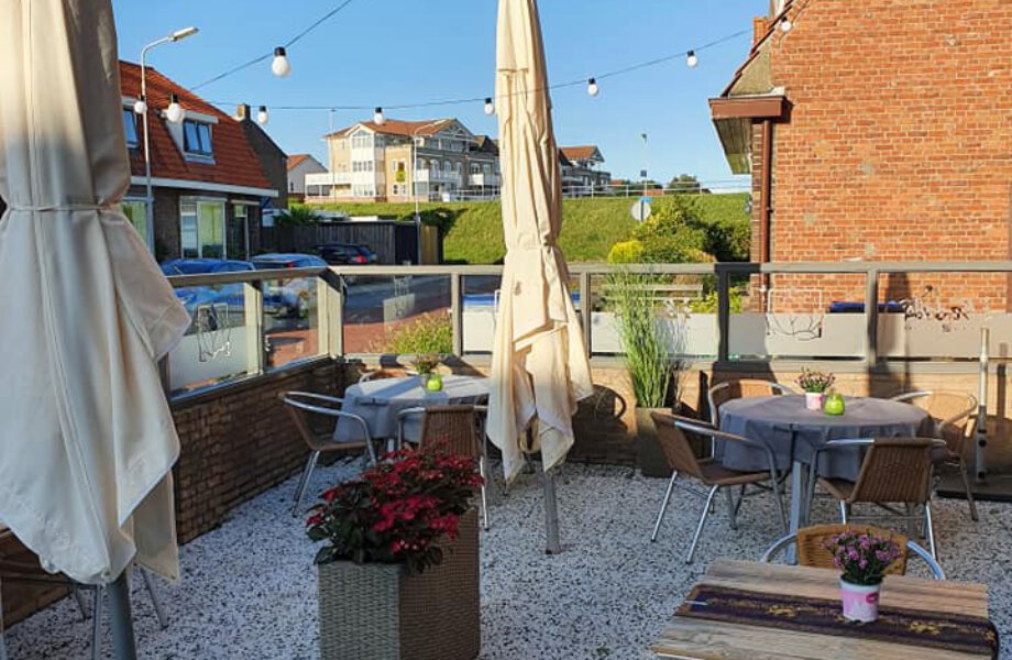 Terras Thong Thai met tafels, bloembak en parasols