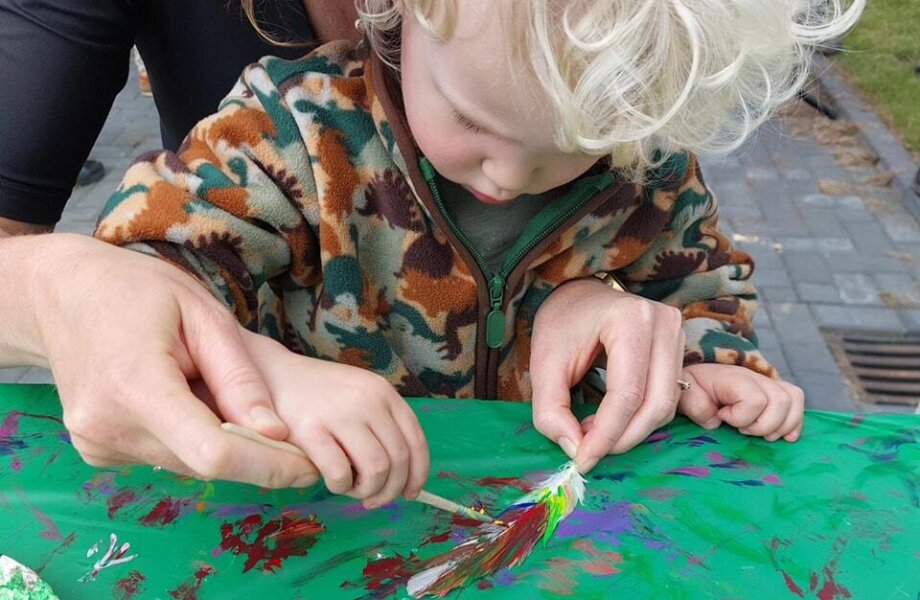 Moeder en zoon verven een veer