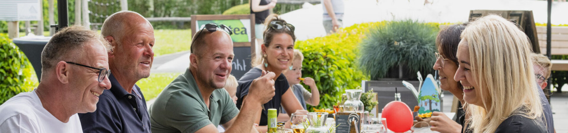 Groep mensen die eten en drinken  op een terras in Wemeldinge
