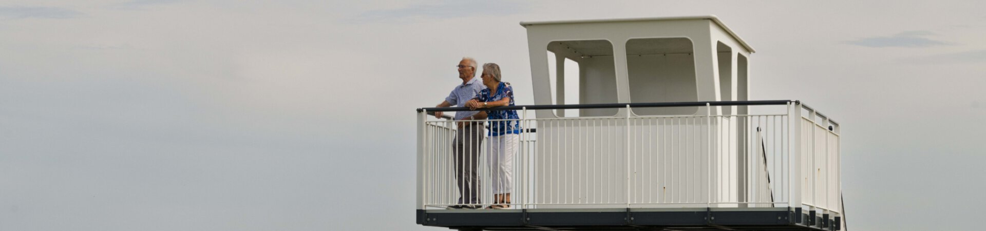 Man en vrouw kijken over de Oosterschelde vanaf het uitzichts- en informatiepunt 't Schip aan Nationaal Park Oosterschelde