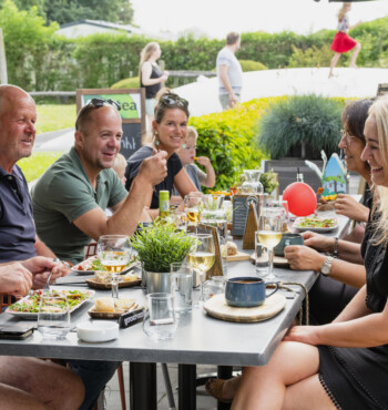 Groep mensen die eten en drinken  op een terras in Wemeldinge