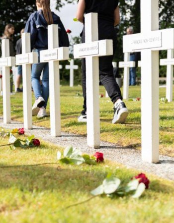 Frans begraafplaats in Kapelle met jongeren die rozen leggen bij de grafkruisen