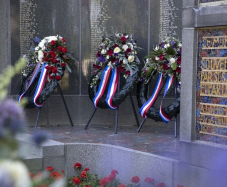 Monument Franse begraafplaats met daarvoor kransen die gelegd zijn tijdens de Franse Herdenking
