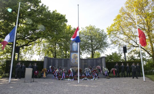 Monument op Franse begraafplaats met daarvoor de Franse, Nederlandse en Marokkaanse vlag halfstok tijdens de Franse herdenking