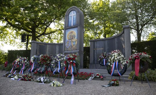 Monument op de Franse begraafplaats met daarvoor bloemenkransen die neergelegd zijn tijdens de Franse Herdenking